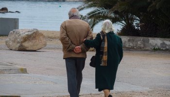 Ηλικιωμένο ζευγάρι περπατά στην παραλία